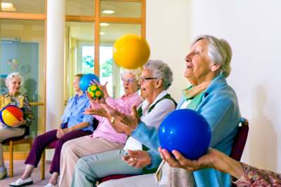 5 elderly women playing with colorful balls